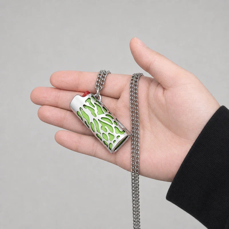 porta-isqueiro-bic-mini-j5-colar-chama-verde-na-mao - Porta-isqueiro BIC Mini J5 com colar chama verde segurado na mao, mostrando tamanho e acabamento.