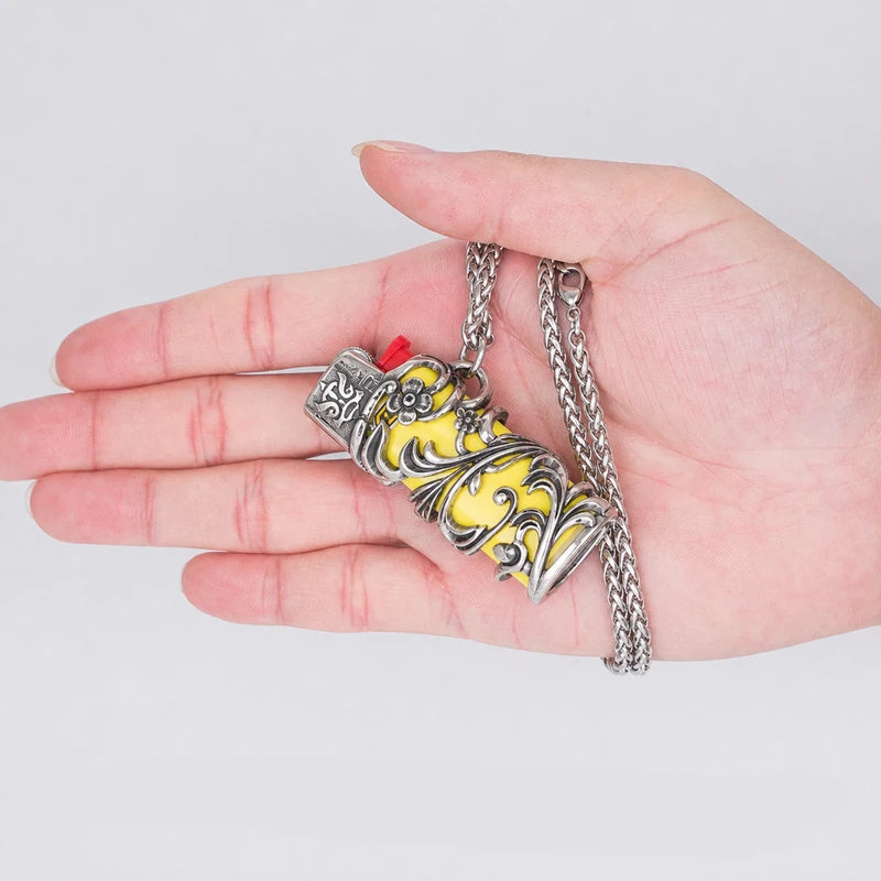 porta-isqueiro-bic-mini-j5-colar-amarelo-tribal-na-mao - Porta isqueiro BIC Mini J5 com colar amarelo tribal segurado na mao, mostrando tamanho compacto.