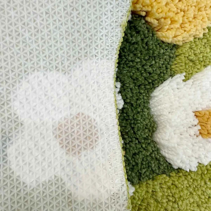 Detalhe da textura tufted e da base emborrachada do tapete de margaridas