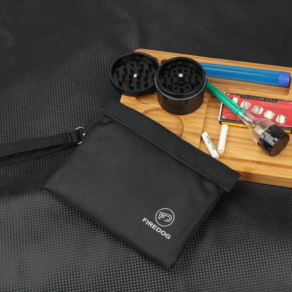 bolsa-anti-odor-preta-uso-com-alca-e-acessorios - Bolsa anti odor preta em uso com alca de mao e itens pequenos.