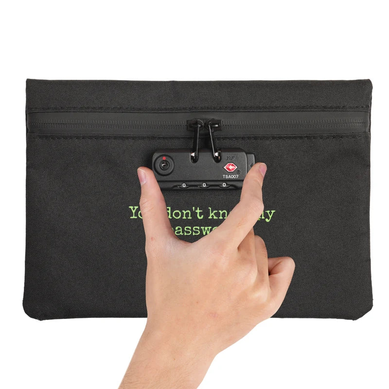bolsa-com-senha-preta-detalhe-botao-e-cadeado - Mao pressionando a trava numerica da bolsa com senha preta.