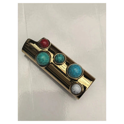 porta-isqueiro-bic-luxo-pedras-turquesa-detalhe-pedras - Detalhe das pedras turquesa, coral e branco no porta-isqueiro BIC luxo dourado.