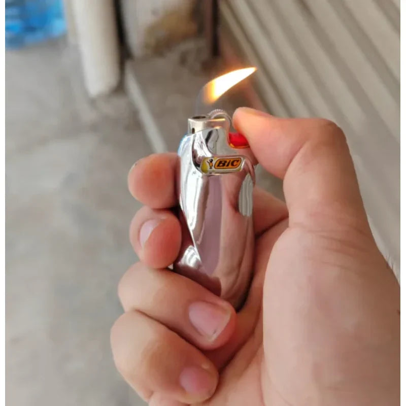 porta-isqueiro-bic-mini-j5-prata-liso-acendendo-na-mao - Porta-isqueiro BIC Mini J5 prata liso sendo usado na mao com chama acesa.