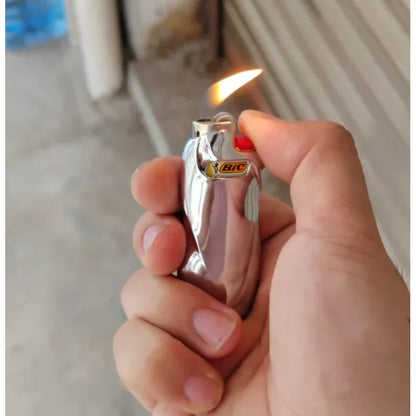 porta-isqueiro-bic-mini-j5-prata-liso-acendendo-na-mao - Porta-isqueiro BIC Mini J5 prata liso sendo usado na mao com chama acesa.